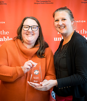 BodyPhoto_Dammys_2024_Awardes Two people holding a dammy award and smiling.