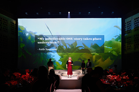 Student speaker Faith Townsend in front of a screen showing Western Kelp.