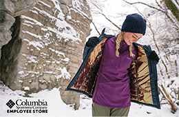 Woman stands outside in snowy landscape smiling and modelling a Columbia Omni-Heat jacket