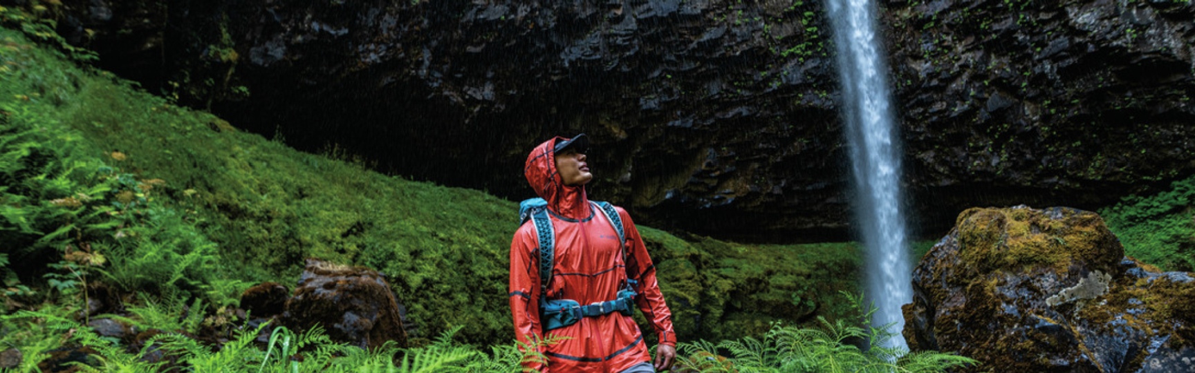 Man wearing Columbia Sportswear clothing while on a hike in a green forest