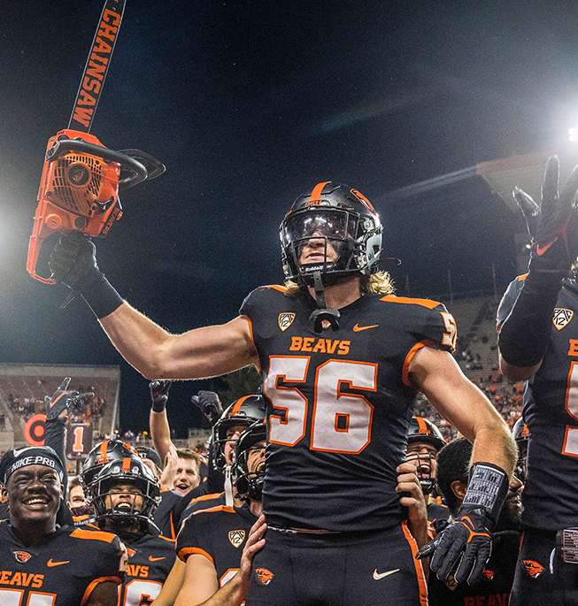 653x685_FeaturedImage_Saw OSU Beaver football player with saw in his hand with other players on the field