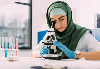 person looking through a microscope