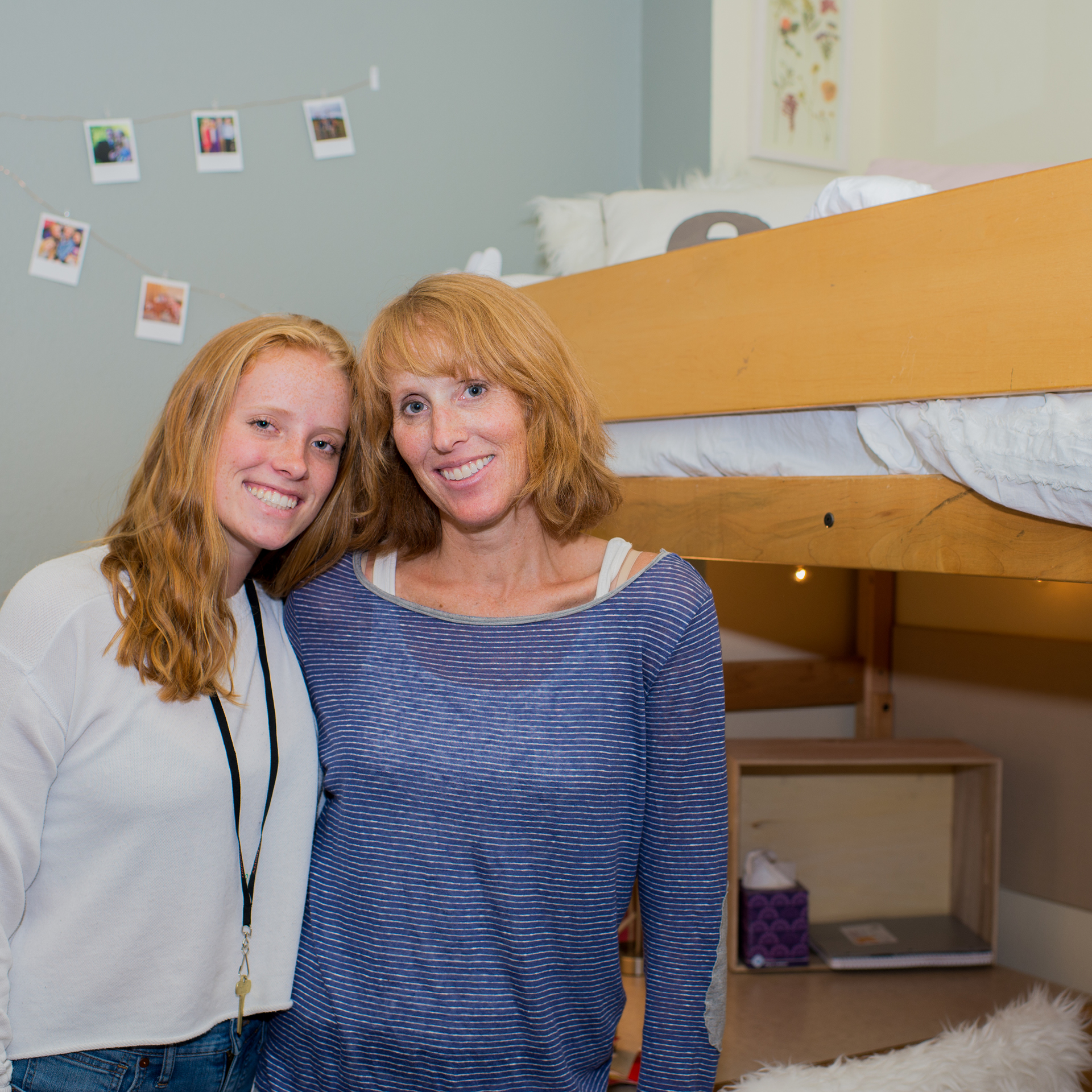 Mother and daugther smiling in a student dorm with bunkbed behind them