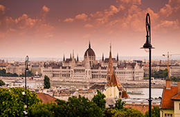 260x170_EventThumbnail_HeartEurope Budapest, Hungary at sunset. A white cathedral looking building along a river.