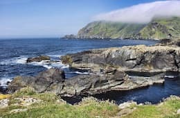 Shetland Isles with rocking coast, blue waters and blue skies with incoming cloud coming in