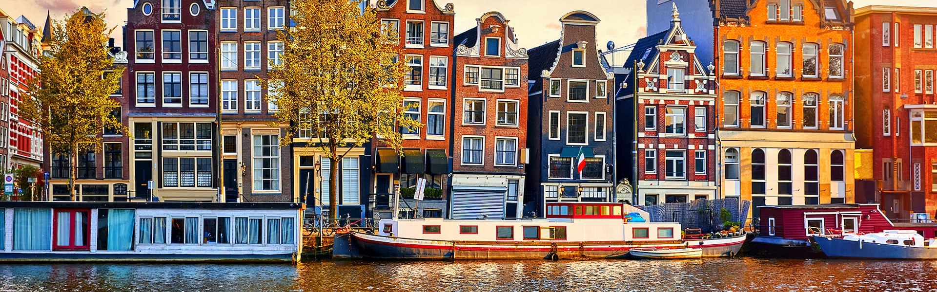 Canal in Amsterdam with unique, colorful houses and beautiful sky