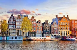 Canal in Amsterdam with unique, colorful houses and beautiful sky