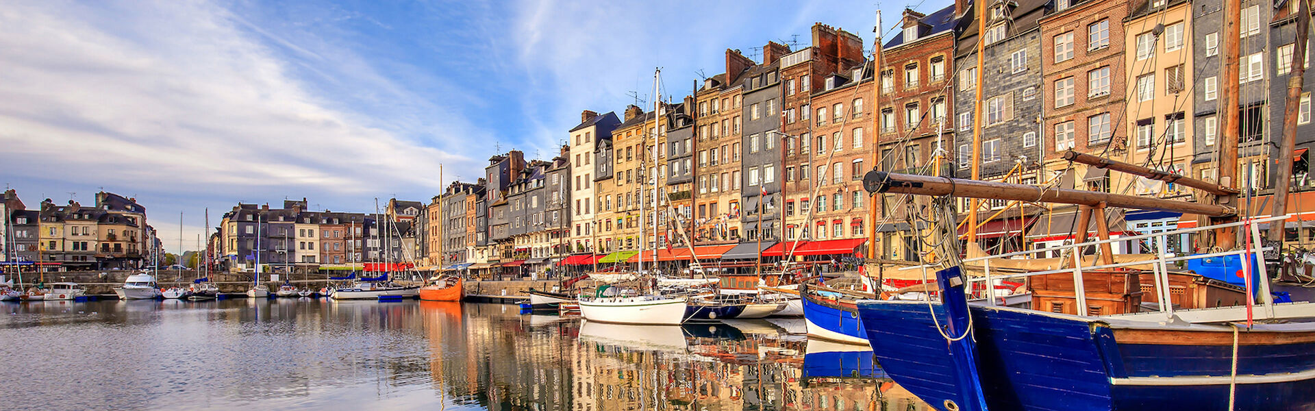 Honfleur's harbor with colorful boats and stacked buildings