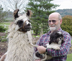 Glen Pfefferkorn with one of his llamas and holding his dog