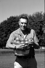 Baggett-Frazier in a field holding vegetables, black and white photo