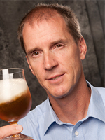 Thomas Shellhammer headshot with glass of beer in his hand