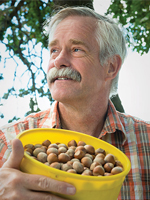 Headshot of Shawn Mehlenbacher holding a yellow bowl of hazelnuts