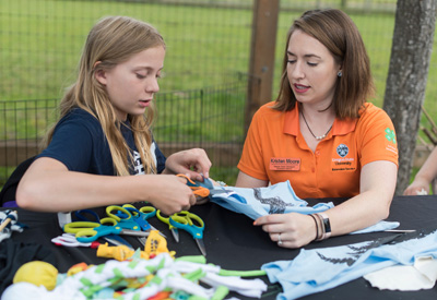 Kristen Moore working with a young student outside at 4-H