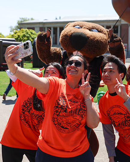 Students take a selfie with Benny the Beaver on the OSU Corvallis campus during Dam Proud Day celebrations