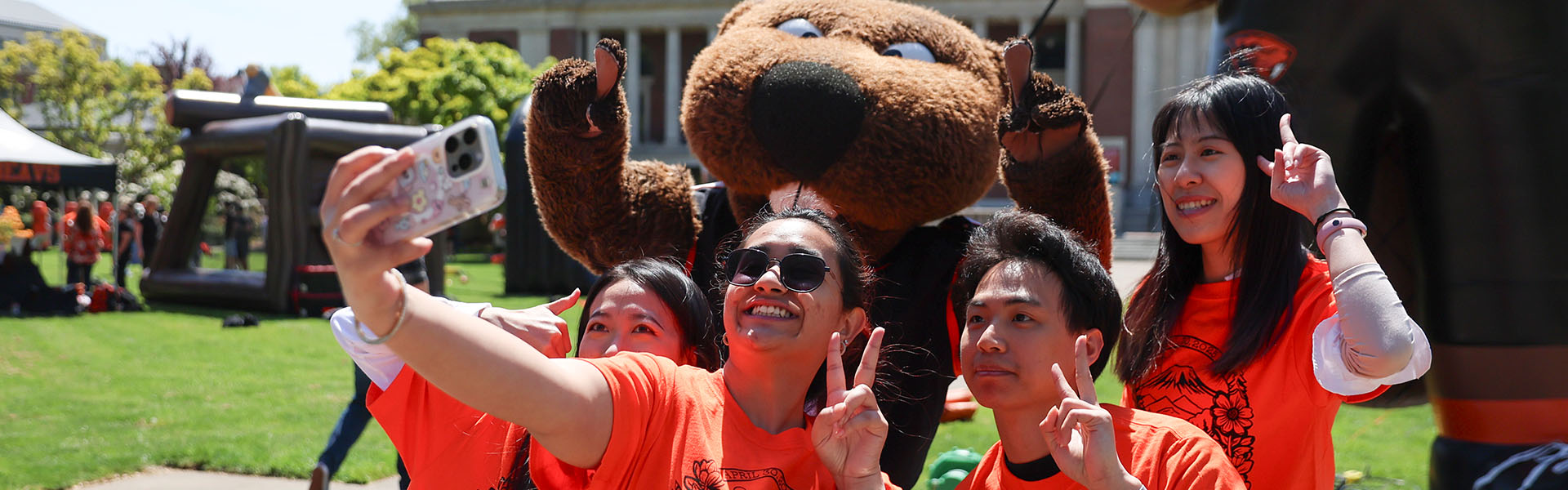 DPD_0000_043025 Dam Good Day 166_Banner Photo of students taking a selfie with Benny the Beaver on Dam Proud Day