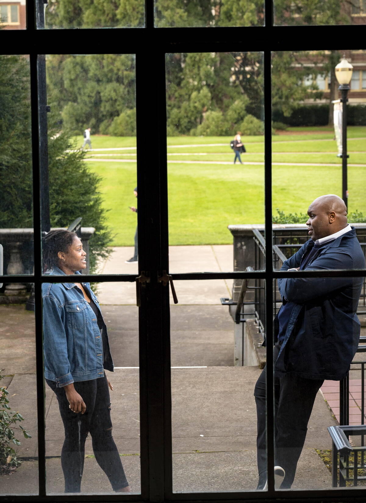 Dorian Smith talking with an OSU student, shot taken from inside looking out of a window of them talking outside