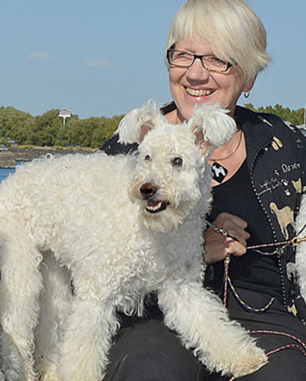 Levy with white dog on a leash outdoors