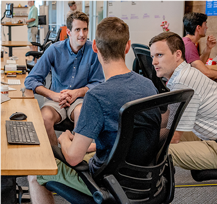 Students sitting together at a computer lab discussing