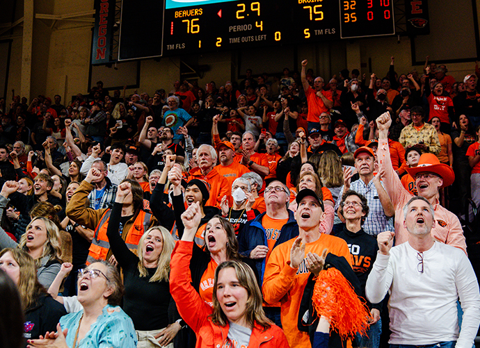 Fans at an OSU beaver event high fiving, wearing beaver gear