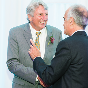 Photo of Dick Fosbury greeting a fan — in this case Dean Javier Nieto of the College of Public Health and Human Sciences