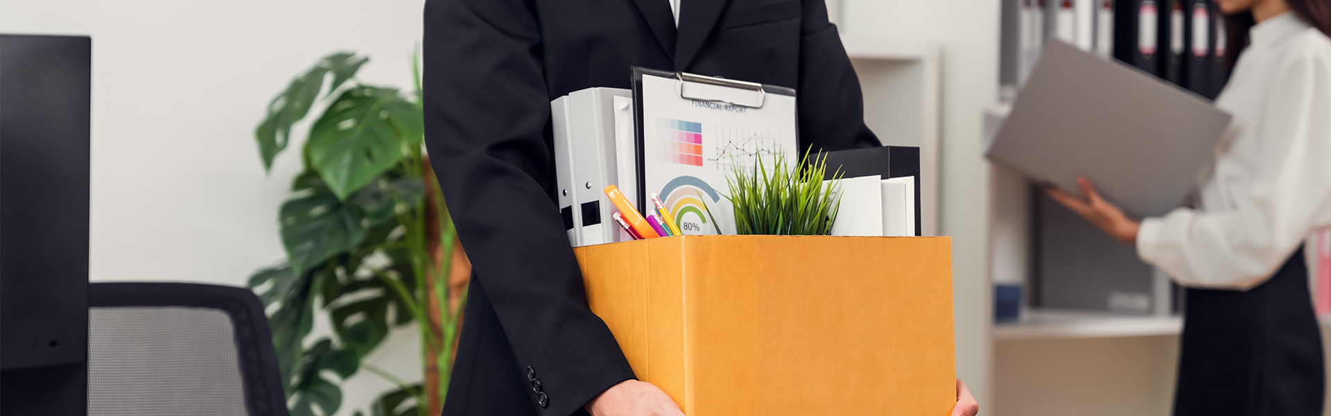 Sitefinity_Banner_1920x600_May 5 Person in a blazer holding a cardboard box with office items.