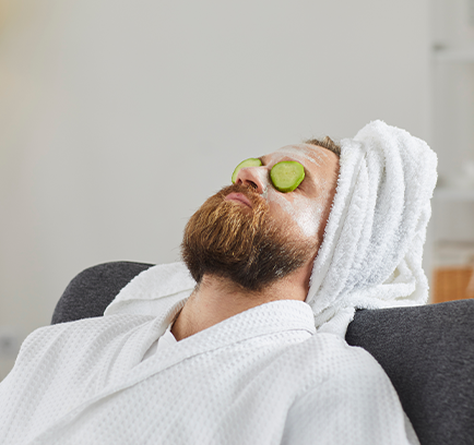 A person in a spa setting with cucumbers over the eyes.