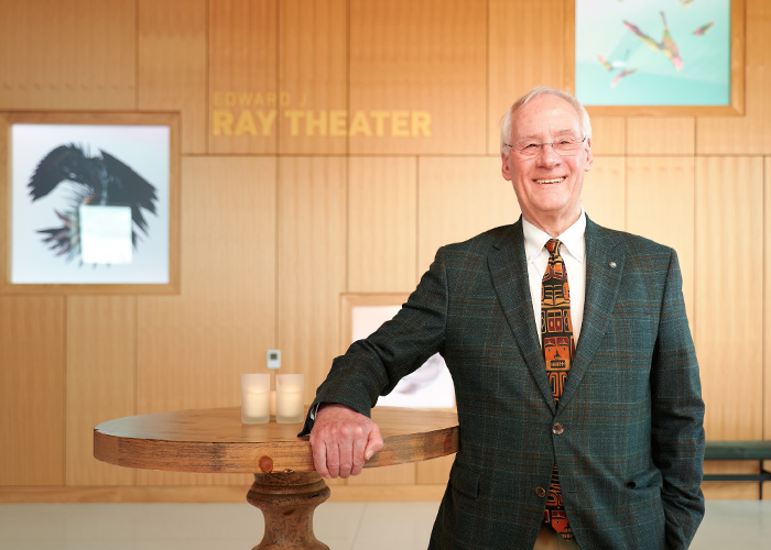 Ed Ray smiling in front of Edward J Ray Theater.